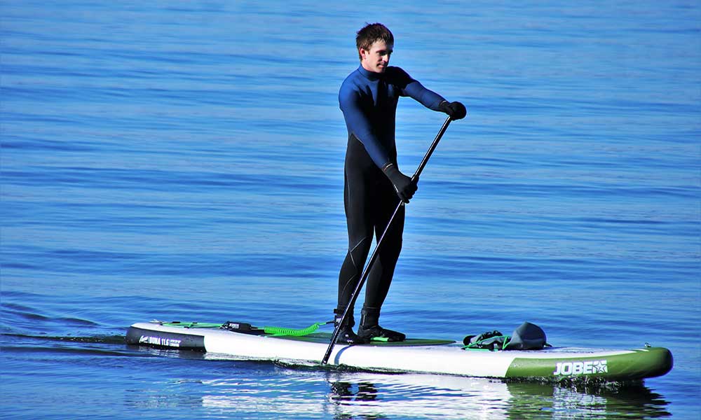 best rated stand up paddle boards which SUP to buy man riding stand up paddleboard in a lake