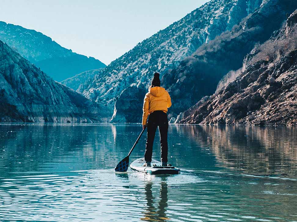 Man on SUP on cold lake displaying SUP paddling conditions 